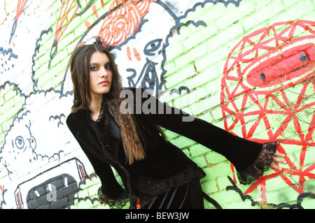 Young woman posing in front of wall graffiti Banque D'Images