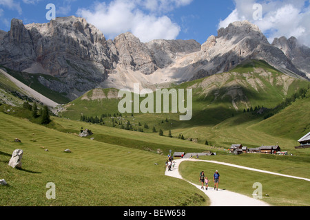 Promenade en famille sur lane près de chalets bois pour la fenaison dans les Dolomites italiennes de l'été Banque D'Images