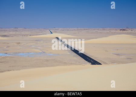 Les dunes de sable à la dérive crossing street, Désert de Libye, Egypte Banque D'Images