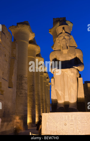 Ramsès II assis lumineux colosse à l'intérieur du temple de Louxor, Louxor, Egypte Banque D'Images