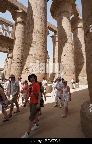 Les touristes entre les piliers de la salle hypostyle de Karnak Temple, Luxor, Egypt Banque D'Images