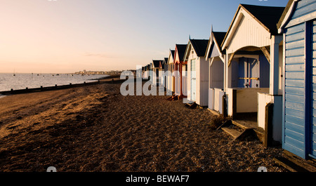 Cabines de plage sur la plage de Stoney à Shoeburyness en fin d'automne le soleil, près de Southend on Sea, Essex, UK Banque D'Images