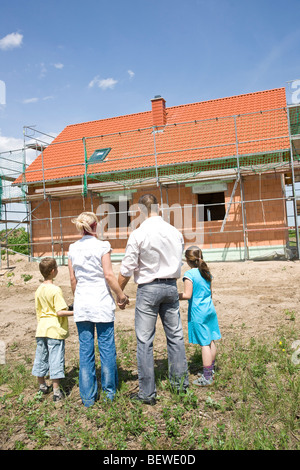 Famille avec deux enfants à la maison en cours de construction, vue arrière Banque D'Images