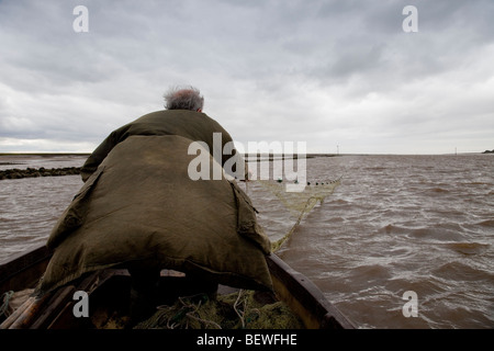 Pêcheur de saumon commerciale avec net sur la rivière Ribble Uk Banque D'Images
