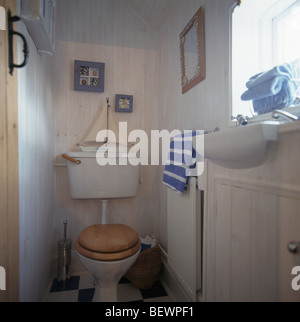 Bateau à voile modèle sur toilettes dans les petits sur le thème de la mer blanc salle de bains avec des murs blanchis à la chaux Banque D'Images