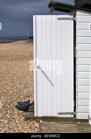 Homme assis dans sa cabane de plage Bexley sur Sea East Sussex England Banque D'Images