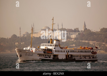 Turquie Istanbul Bosphore ferry avec le palais de Topkapi et de minarets au lever du soleil Banque D'Images