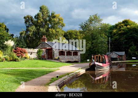 Reflet de pittoresque maison bateau amarré et canal boat sur le canal de Brecon et Monmouth prises à Llangynidr Mid Wales Banque D'Images