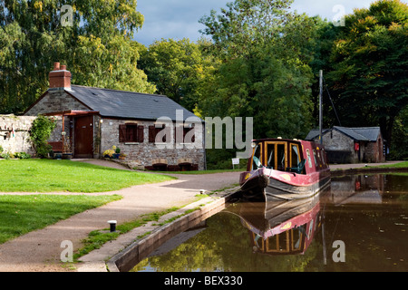 Reflet de pittoresque maison bateau amarré et canal boat sur le canal de Brecon et Monmouth prises à Llangynidr Mid Wales Banque D'Images