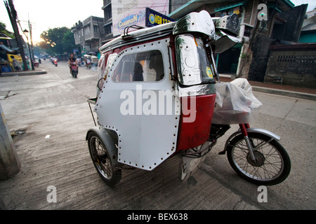 Un tricycle motorisé (rickshaw) dans la ville de Vigan. Banque D'Images