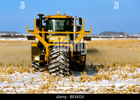 Un TerraGator à l'application de chaux sur un couvert de neige en hiver ; un champ de maïs est en train d'éthanol en passant par en arrière-plan / Illinois, États-Unis Banque D'Images