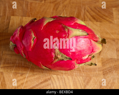 Un Dragon Fruit mûr sur un billot en bois Banque D'Images