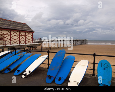 Des planches de surf à la location, à l'extérieur du magasin de surf et jetée à Dharamsala, Cleveland, UK lors d'une froide journée d'automne Banque D'Images