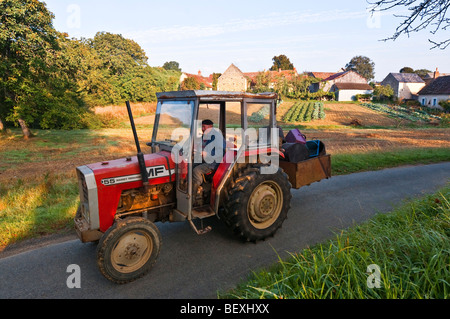 Paysan français ancien conduite tracteur le long de voies étroites - sud-Touraine, France. Banque D'Images