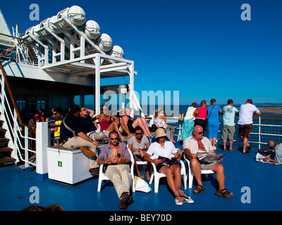 Les passagers se détendre sur un ferry Transmanche, assis au soleil Banque D'Images