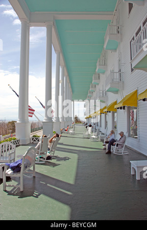 Les gens assis dans des chaises à bascule sur l'avant porche de Grand Hôtel de l'île Mackinac, Michigan Banque D'Images