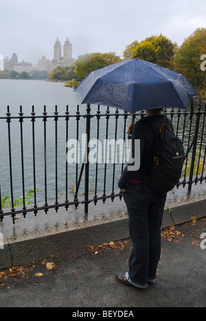 Femme avec parapluie des pluies dans Central Park, New York City. Banque D'Images