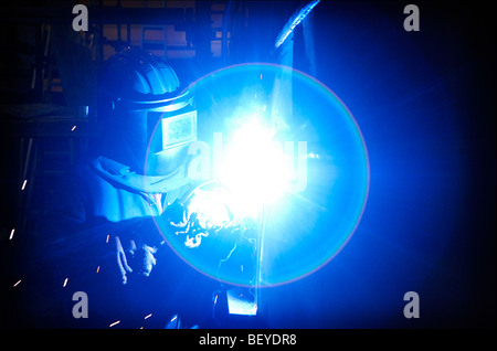 Un soudeur travaille sur la coque d'un navire d'acier dans un chantier naval de Glasgow. Banque D'Images