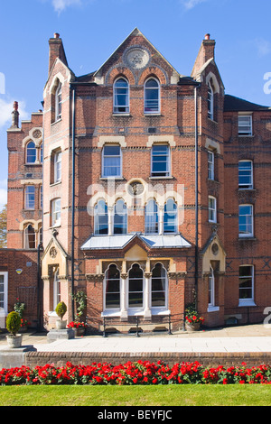 Harrow on the Hill , Harrow School , Druries pension de famille construite 1865 avec les fleurs rouges , pelouse & ciel bleu et nuages whispy Banque D'Images