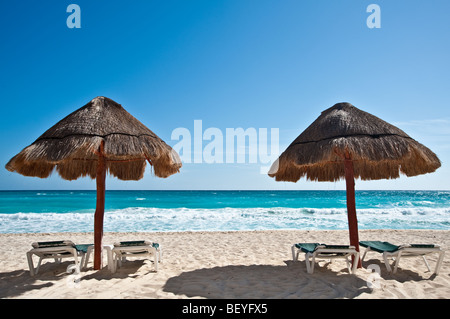 Deux parasols par une plage tropicale Banque D'Images