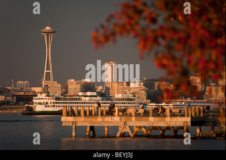 Un beau coucher de soleil d'automne d'une plage Alki pier public avec le Space Needle et ferry boats passe par sur la baie Elliott. Banque D'Images