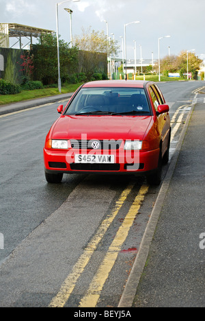 Une Volkswagen Polo rouge garé sur double lignes jaunes, Bolton, uk Banque D'Images