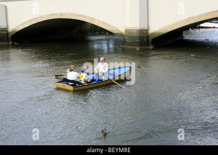 Un homme à l'aide d'avirons dans un petit bateau à rames sur la rivière Frome à Wareham, Dorset Banque D'Images