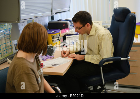 Le médecin et le patient dans une salle de consultation à un GP surgery Banque D'Images