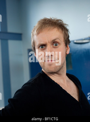 Portrait d'un jeune homme tirant une Drôle de tronche (Londres, UK) Banque D'Images