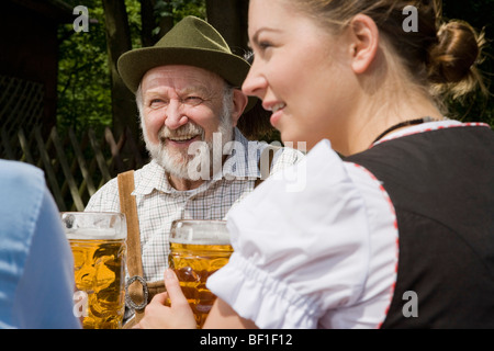 Trois personnes dans un jardin de bière Banque D'Images