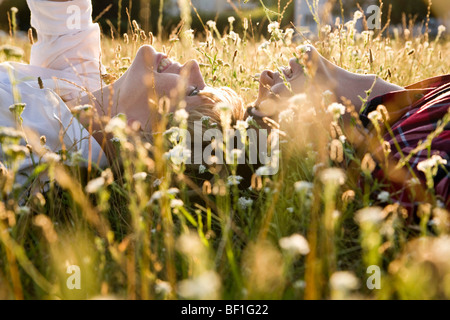 Un jeune couple lying in sur le dos dans l'herbe, close-up Banque D'Images