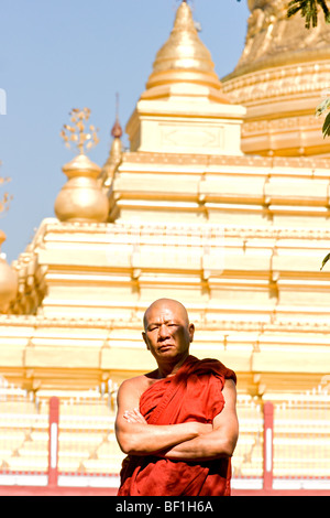 Monk posant devant un stupa, à Mandalay, Myanmar. Banque D'Images