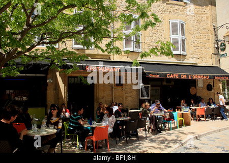 La rue animée et restaurant en plein air dans le village de Lourmarin Banque D'Images