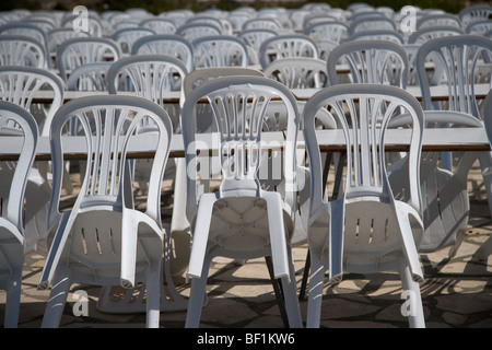 Des rangées de chaises en plastique empilés vides à la terrasse d'un café et restaurant Banque D'Images