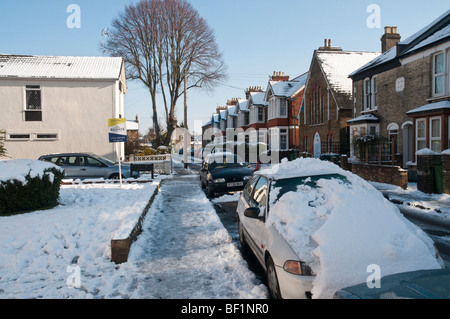 Une rue de banlieue couvert de neige avec ciel bleu Banque D'Images