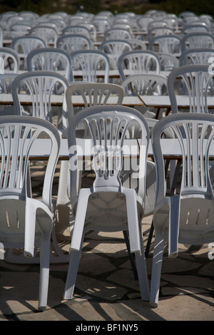 Des rangées de chaises en plastique empilés vides à la terrasse d'un café et restaurant Banque D'Images