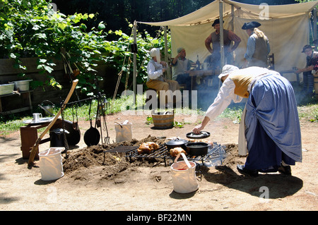 Woman cooking in camp de tentes militaires en costume - Guerre de la Révolution américaine (années 1770) Époque re-enactment Banque D'Images