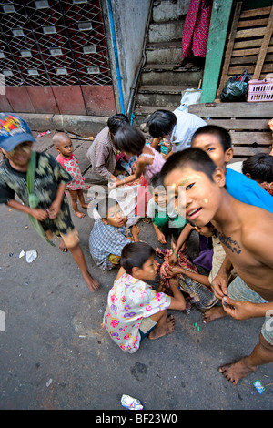 Groupe de partage pour enfants chef d'une vache dans la rue de yangoon, myanmar Banque D'Images