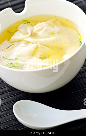 Wonton soup en blanc bol avec cuillère Banque D'Images