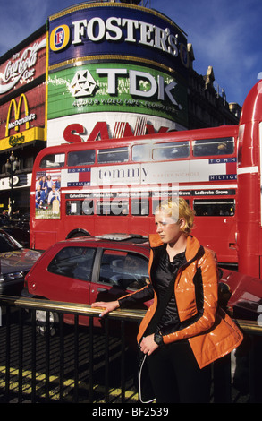 Fille en veste orange, Piccadilly Circus, ville de Londres. Angleterre, Royaume-Uni, Grande Bretagne, Europe Banque D'Images