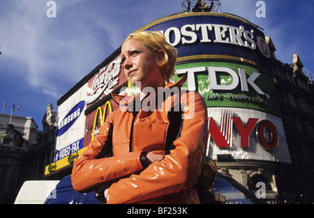 Fille avec veste orange à Piccadilly Circus, ville de Londres. Angleterre, Royaume-Uni, Grande Bretagne, Europe Banque D'Images