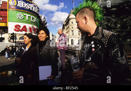 Les Punks et les touristes à Piccadilly Circus, ville de Londres. Angleterre, Royaume-Uni Banque D'Images