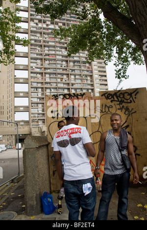 Les jeunes hommes dans l'avant du grafitti et tours Trellick highrise Banque D'Images