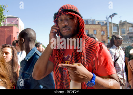 Jeune homme portant keffieh traditionnel talking on mobile phone Banque D'Images