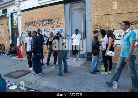 La jeunesse de déconner dans la rue de barricadèrent shop fronts. Banque D'Images