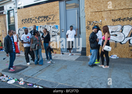 La jeunesse de déconner dans la rue de barricadèrent shop fronts. Banque D'Images