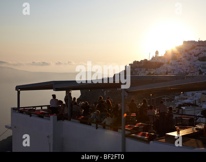 Diners bénéficiant d'un coucher de soleil sur la caldeira de Santorin. Grèce Banque D'Images