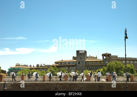 Les commerçants illégaux avec leurs marchandises enveloppé dans des draps ayant été déplacé par la police près du Ponte Sant'Angelo, Rome Banque D'Images