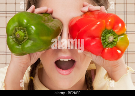 Close-up of a Girl holding bell peppers sur ses yeux Banque D'Images