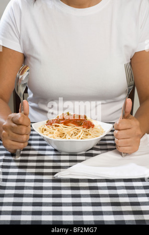 Mid section Vue d'une femme avec un bol de spaghetti Banque D'Images